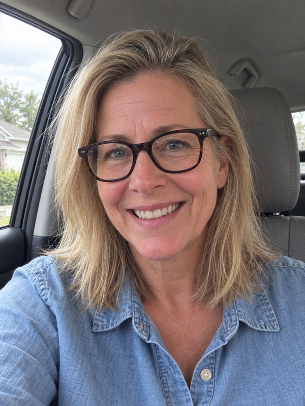 Portrait of Susan, a smiling woman with blonde hair and glasses